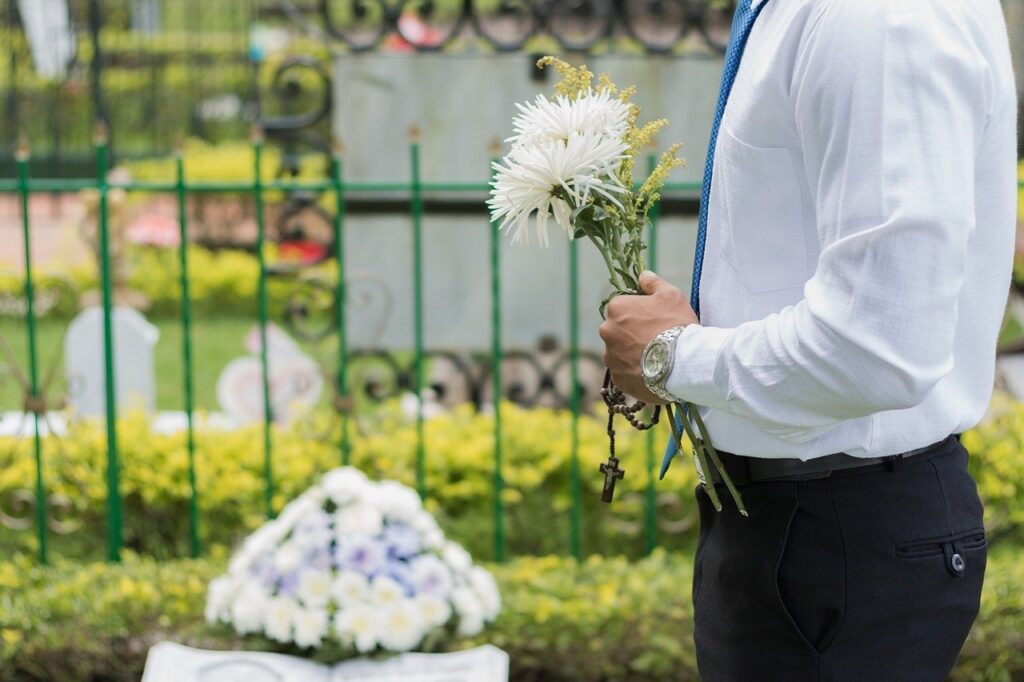 person holding flowers at funeral